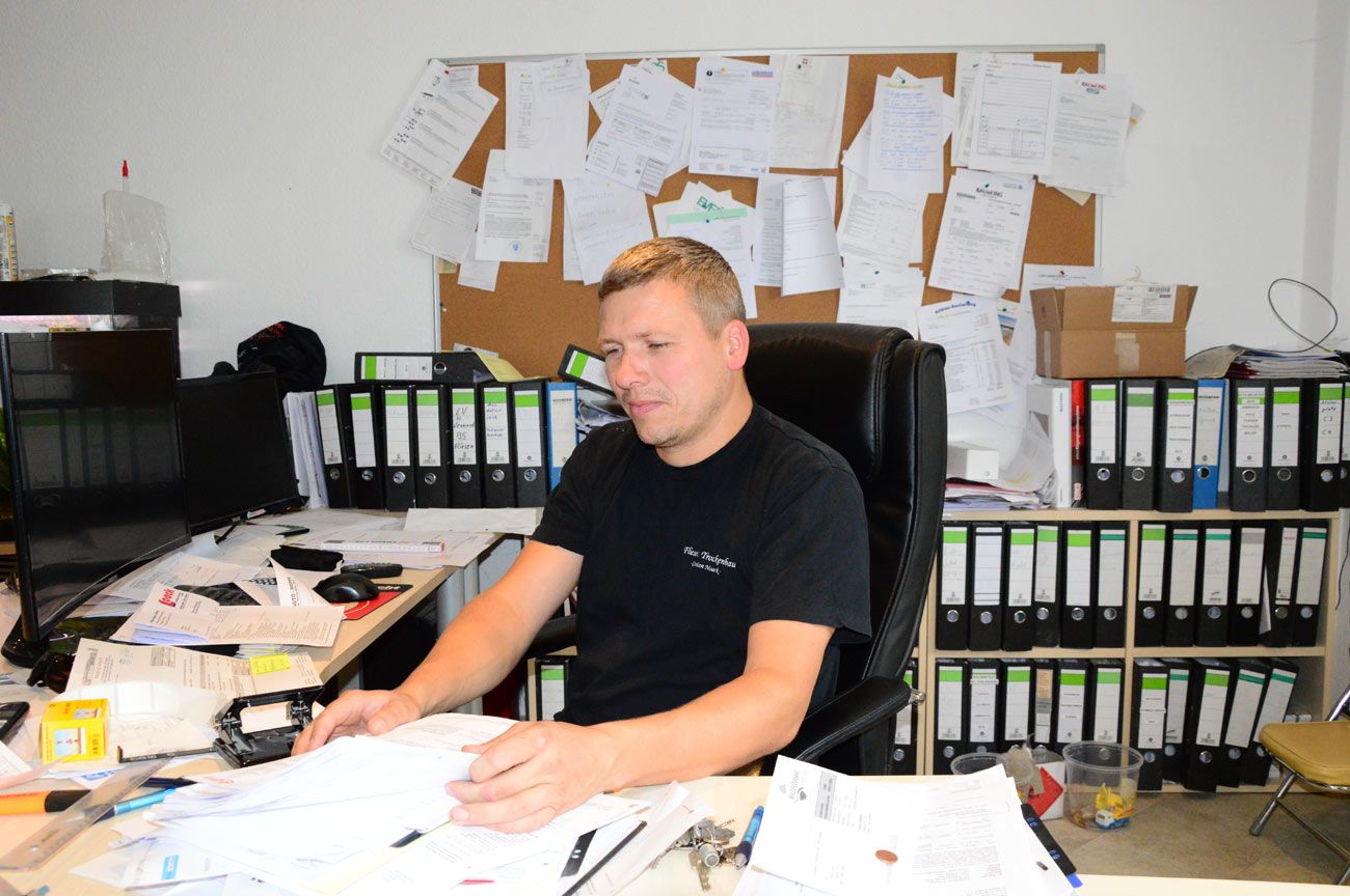 Christian Noack sitzt im Büro und liest einen Bericht